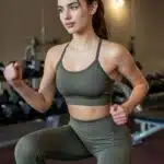 Woman exercising in a gym wearing custom gym wear from a professional custom gym wear supplier.